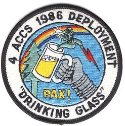 4th Airborne Command and Control Squadron Deployment 1986
This patch commemorates the alternate basing of the unit's aircraft (and most of the rest of the squadron as well; i.e., unit relocation) during a good portion of 1986 while the runway was being renovated in preparation for the new B-1Bs. "Drinking Glass" is a pun on the "Looking Glass" mission and "PAX" is a pun on the PACCS (Post Attack Command & Control System) mission. The genie provides a clue to the unit's home away from home during the reconstruction (Minot), which is where two of the four alert EC-135s were normally forward deployed anyway. 
